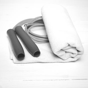 fitness equipment:white towel,jumping rope on white wood table black and white color style