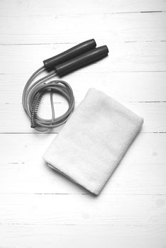 fitness equipment:white towel,jumping rope on white wood table black and white color style