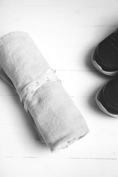 fitness equipment : running shoes,towel and measuring tape on white wood table black and white color style