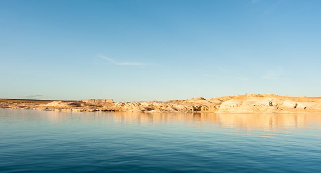 Lake Powell stunning blue wate and red rock cliffs reflecting at sunset  Arizona USA