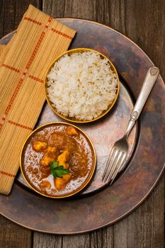 Overhead view of chicken madras served with rice.