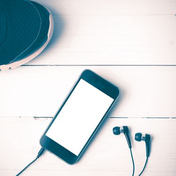 running shoes and phone on white wood table vintage style