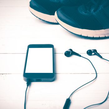 running shoes and phone on white wood table vintage style