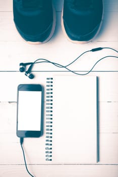 running shoes,notebook and phone on white wood table vintage style