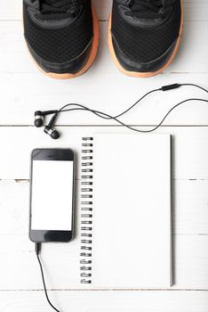 running shoes,notebook and phone on white wood table