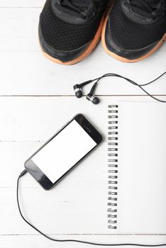 running shoes,notebook and phone on white wood table