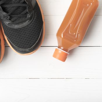 running shoes and orange juice on white wood table