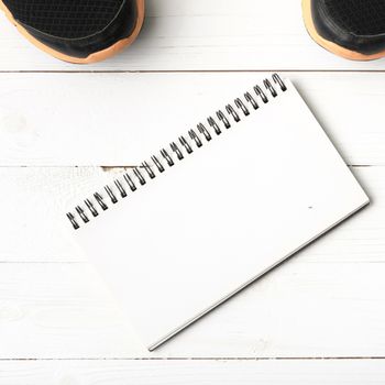 running shoes and notepad on white wood table