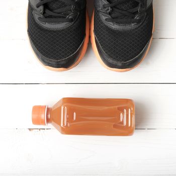 running shoes and orange juice on white wood table