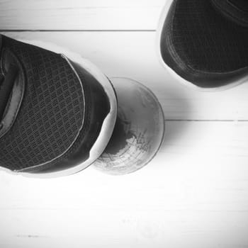 running shoes and earth ball on white wood table concept world healthy black and white tone color style