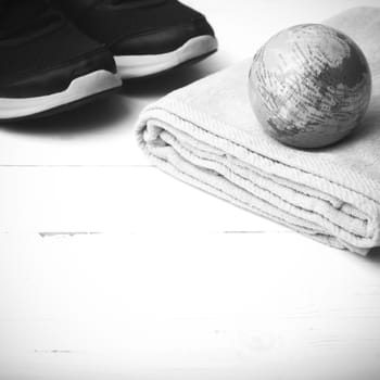 running shoes,towel and earth ball on white wood table concept world healthy black and white tone color style