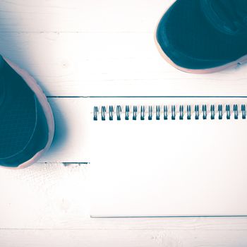 running shoes and notepad on white wood table vintage style