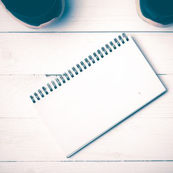 running shoes and notepad on white wood table vintage style