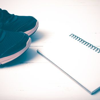 running shoes and notepad on white wood table vintage style