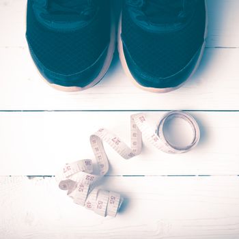 running shoes and measuring tape on white wood table vintage style