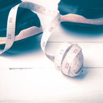 running shoes and measuring tape on white wood table vintage style