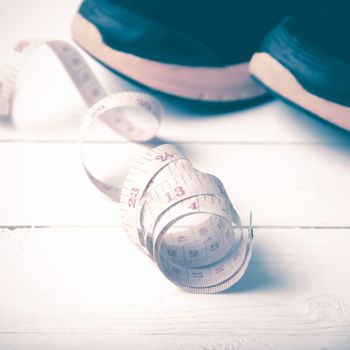 running shoes and measuring tape on white wood table vintage style