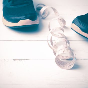 running shoes and measuring tape on white wood table vintage style