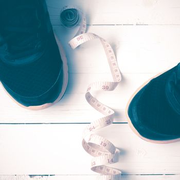 running shoes and measuring tape on white wood table vintage style