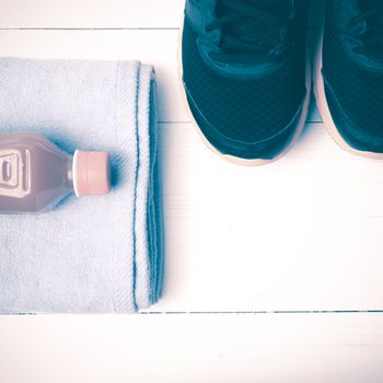running shoes,towel and orange juice on white wood table vintage style
