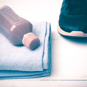 running shoes,towel and orange juice on white wood table vintage style