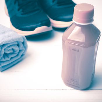 running shoes,towel and orange juice on white wood table vintage style