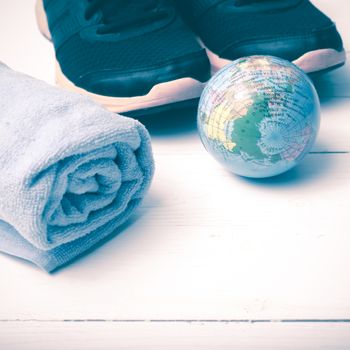 running shoes,towel and earth ball on white wood table concept world healthy vintage style