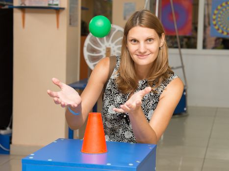 Volgograd, Russia - August 31, 2015: A girl holding hands under a flying ball - entertaining science museum exhibit Einstein in Volgograd