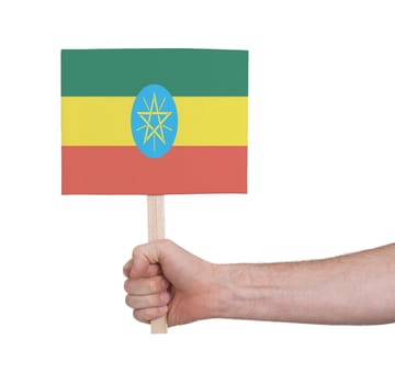 Hand holding small card, isolated on white - Flag of Ethiopia