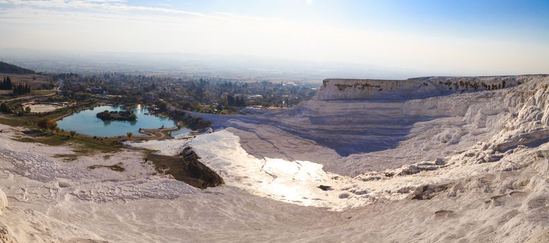 Panoramic view of white hill in Pamukkale and pools on clear sky background, Denizli, Turkey.