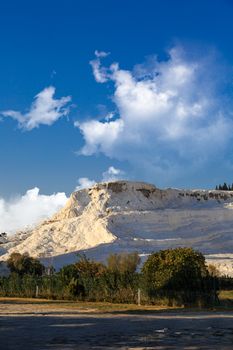 View of white hill in Pamukkale on cloudy background, Denizli, Turkey.