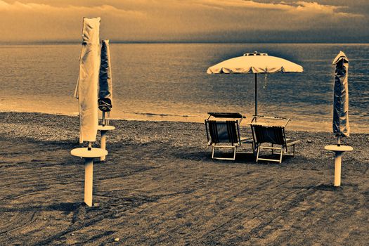 Beach Umbrella and Sun Bed in the Sandy Coast near the Italian City of Minori at Sunset