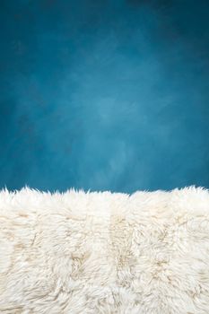 white fur carpet and blue painted wall , use for background