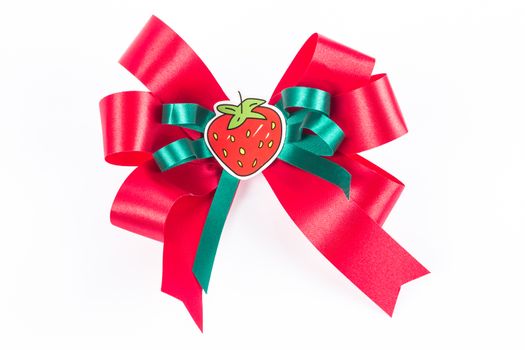 Red bow with small green ribbon and strawberry label on white background