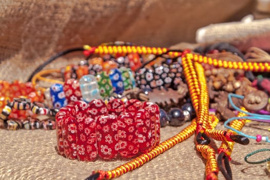 Different bright, multi-colored jewelry of handwork in a sunlight