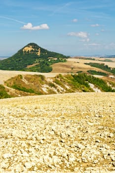 Plowed Sloping Autumn Field in Tuscany on the Background of Green Hill, Italy