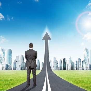 Businessman standing on highway road going up as an arrow in sky