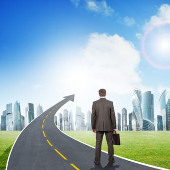 Businessman standing on highway road going up as an arrow in sky