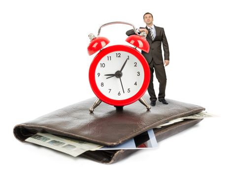 Businessman standing on purse with alarm clock on isolated white background