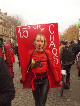 FRANCE, Paris : A woman holds a big red sign reading 1,5 � or chaos during a climate march organized in Paris on December 12, 2015 as COP 21 negotiations end. 