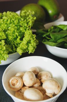 fresh mushrooms in plate with greens on a background