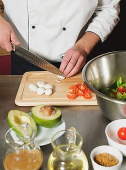 chef cutting mushrooms on table with knife