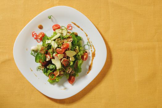 fresh gourmet salad on white platewith avocado