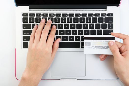 Shot from top of Human next to laptop with credit card on white background
