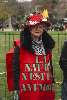 FRANCE, Paris : A woman wears an apron reading Nature is not for sale on the Champ-de-Mars, near Paris Eiffel tower on December 12, 2015 as thousands of people demonstrate for environment protection.  