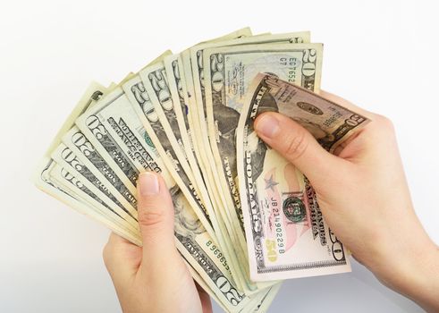person with hands counting dollars on white background