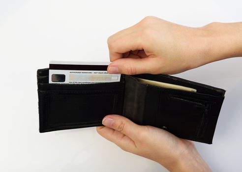 Person taking credit card from black opened wallet