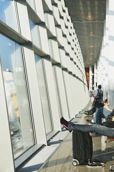 Passanger waitnig for flight next to window in airport