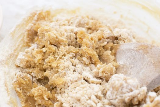Close-up of cookie dough being mixed with a wooden spoon