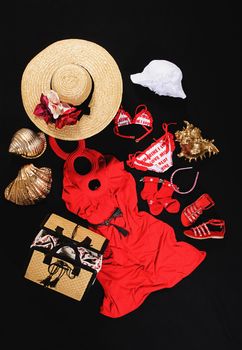 Dress, hats, shoes and bag on black background for goin in beach